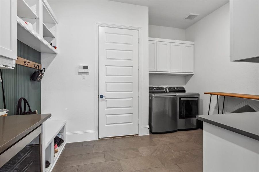 Oversized laundry room with built in beverage cooler, mudroom accents and extra storage