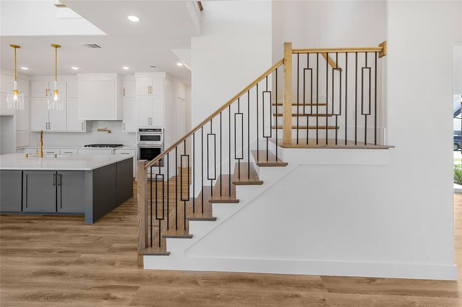 Stairway with hardwood / wood-style floors and sink