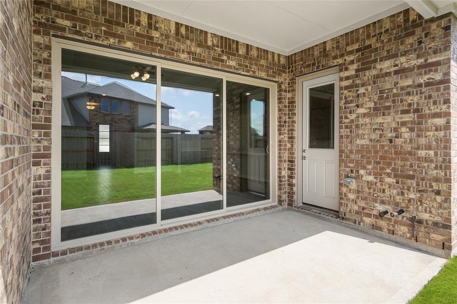 The covered patio is generously sized, providing ample space for various outdoor activities.
