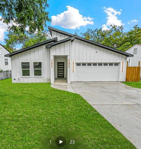 Modern inspired farmhouse with a front lawn and a garage