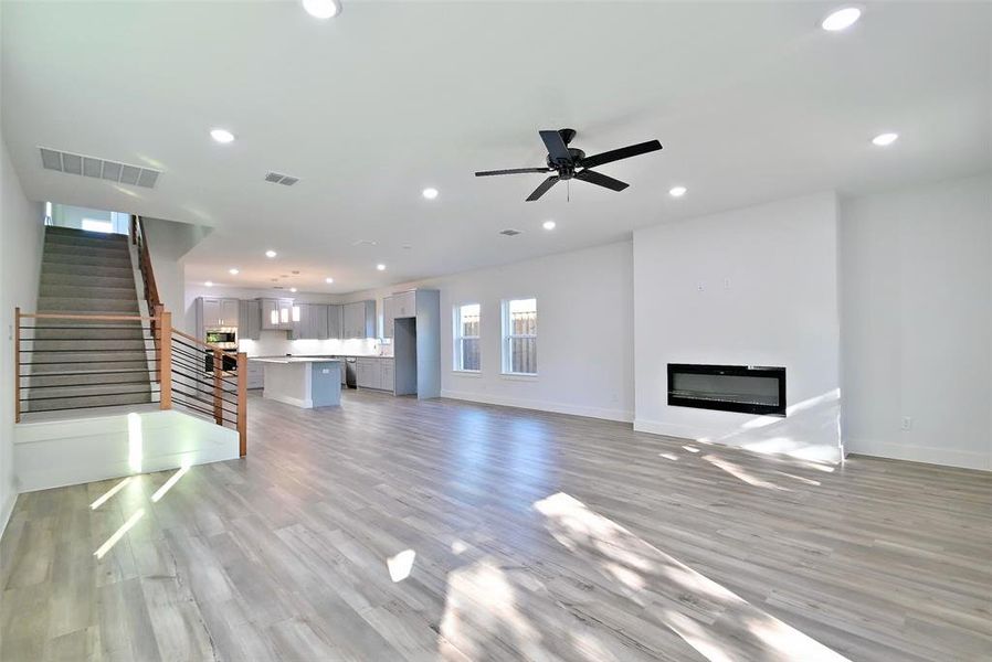 Unfurnished living room with ceiling fan and light hardwood / wood-style flooring