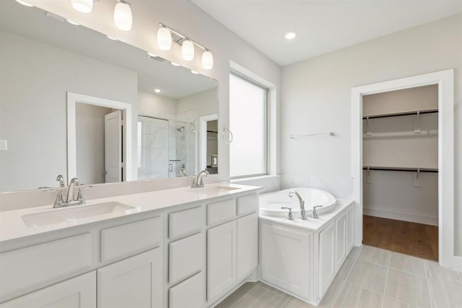 Bathroom featuring plus walk in shower, tile patterned floors, and vanity