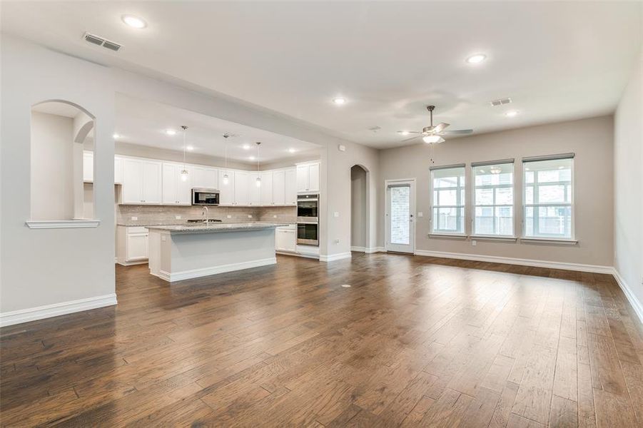 Unfurnished living room featuring dark hardwood / wood-style flooring, sink, and ceiling fan