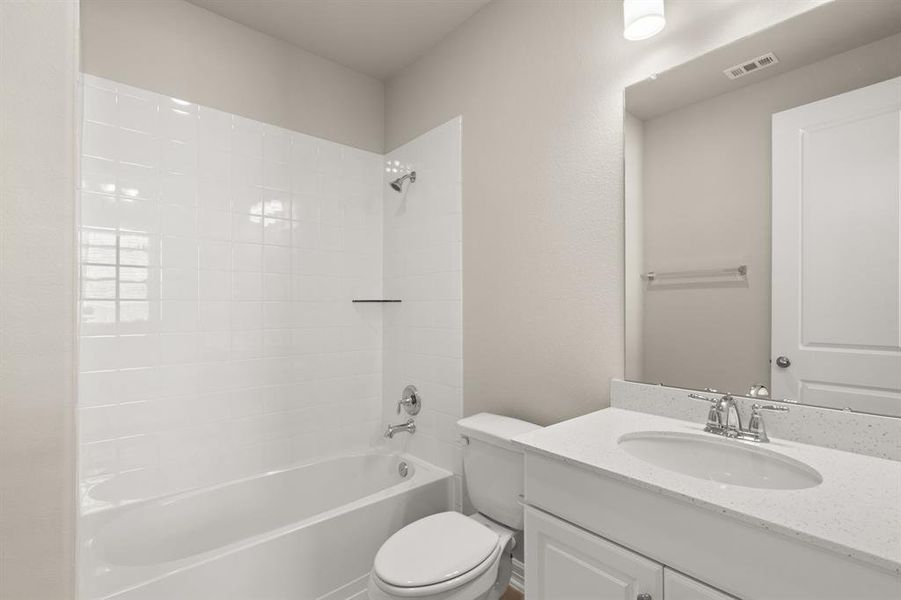 The secondary bath features tile flooring, white cabinetry and light countertops and a shower/tub combo. Perfect for accommodating any visiting family and friends.