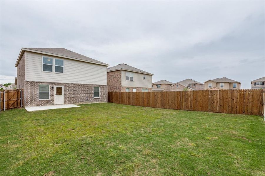 Back of property featuring a patio area and a yard