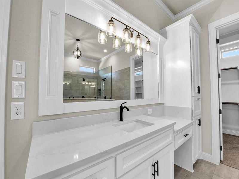 Bathroom with ornamental molding, vanity, tile patterned floors, and a shower with door