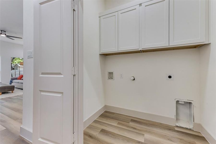 Laundry room featuring hookup for a washing machine, electric dryer hookup, and cabinets