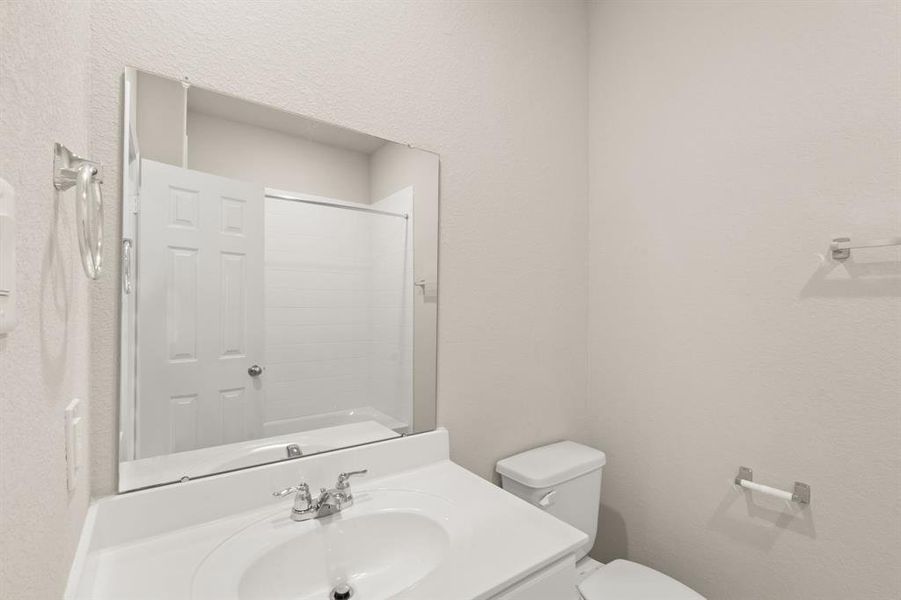 The secondary bath features tile flooring, white cabinetry and light countertops and a shower/tub combo. Perfect for accommodating any visiting family and friends.