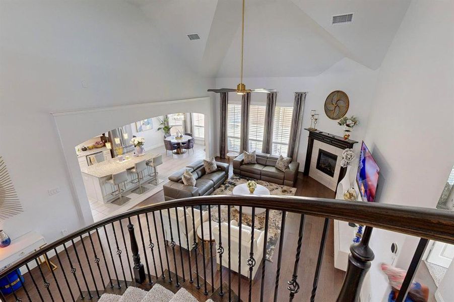 Stairway with high vaulted ceiling, hardwood / wood-style flooring, and ceiling fan