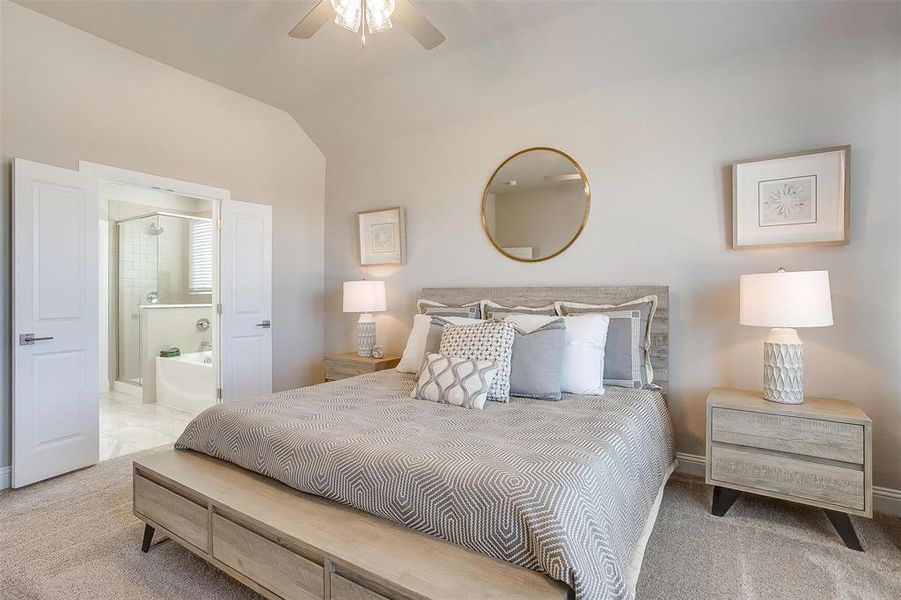 Carpeted bedroom featuring lofted ceiling, ceiling fan, and ensuite bath