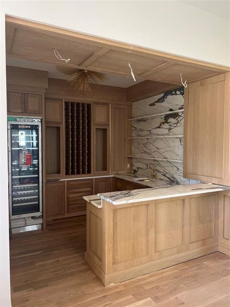 Bar with white oak cabinetry and Arabescato marble countertops. Bar includes sink, Thermador wine column and Scotsman ice machine.