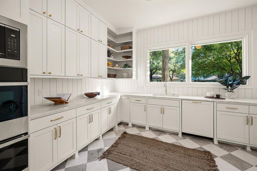 Kitchen featuring white cabinets, ornamental molding, and sink