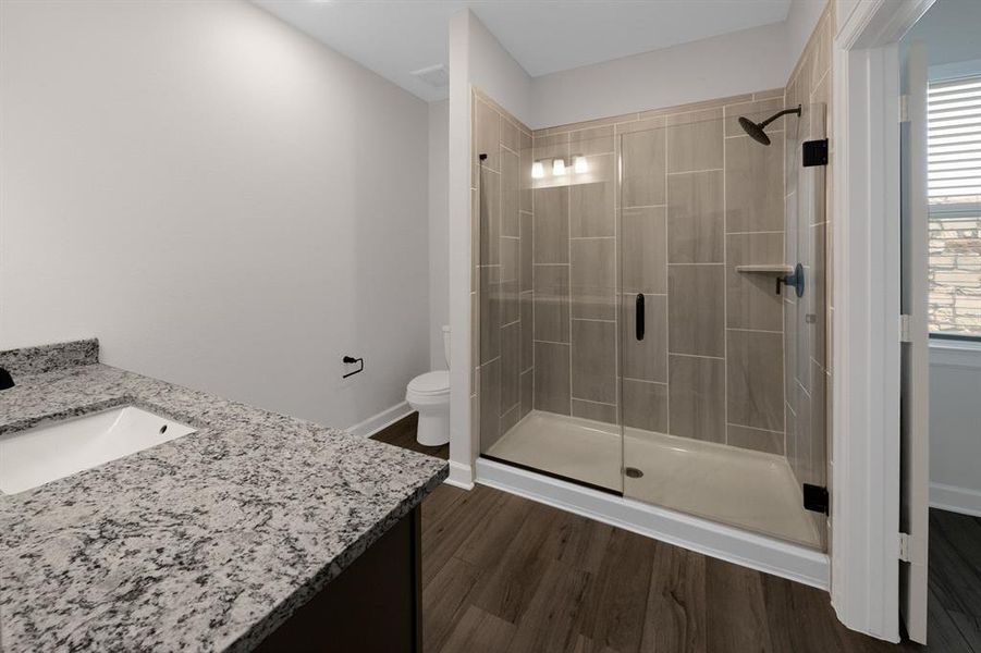 The large en-suite bathroom exudes luxury and relaxation, featuring a spacious walk-in shower that mimics the indulgent atmosphere of a high-end spa, offering a rejuvenating experience right at home.
