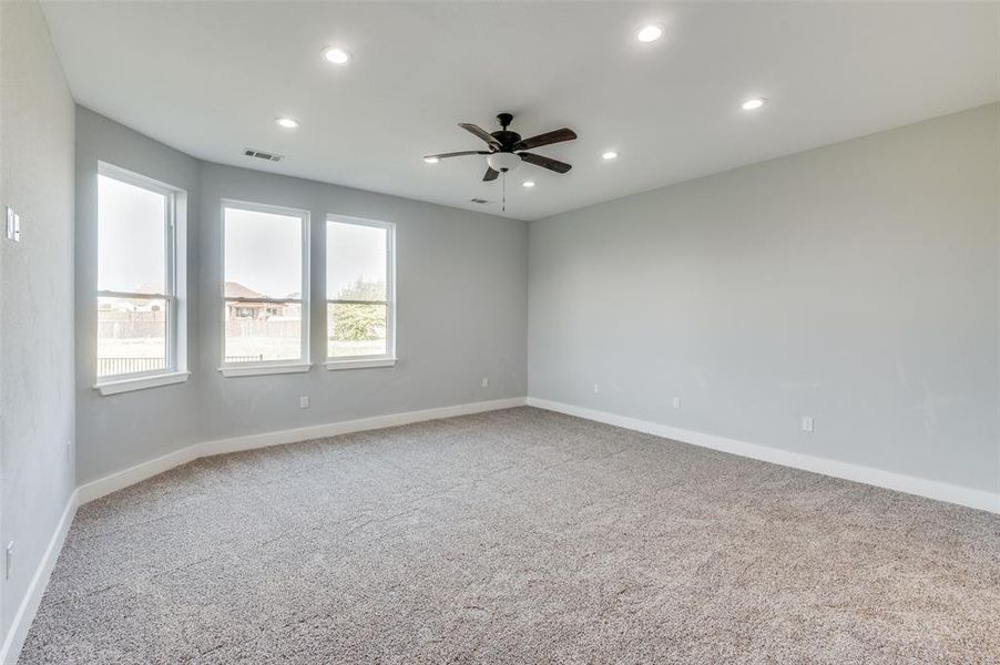 Carpeted empty room featuring ceiling fan