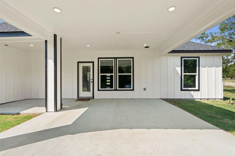 View of exterior entry featuring a yard and a patio area