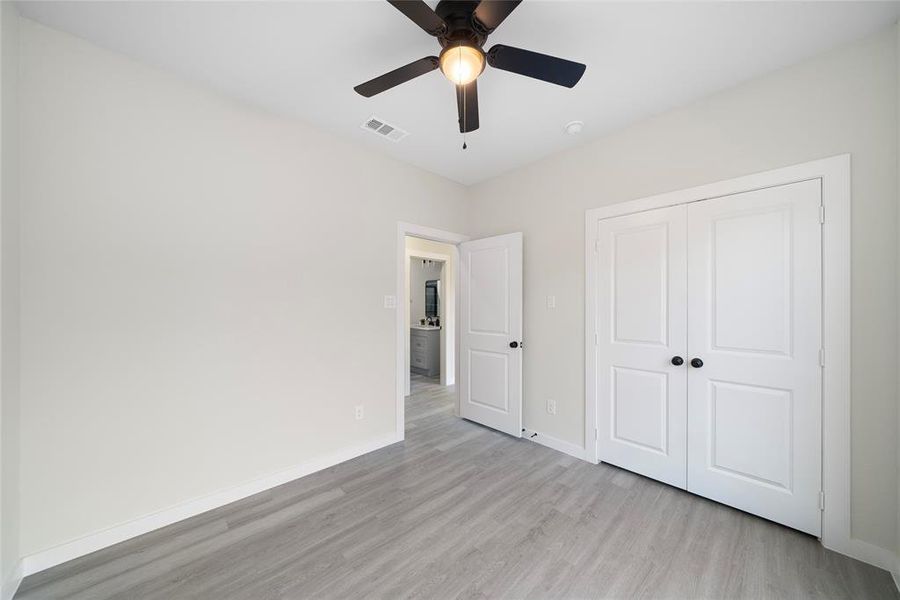 Unfurnished bedroom with a closet, light hardwood / wood-style floors, and ceiling fan