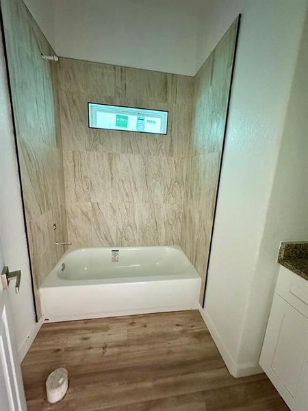 Secondary bathroom with granite counters, ceramic tile tub surround and adjacent to indoor laundry room