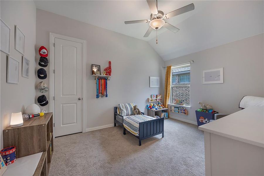 Bedroom featuring light carpet, ceiling fan, and vaulted ceiling