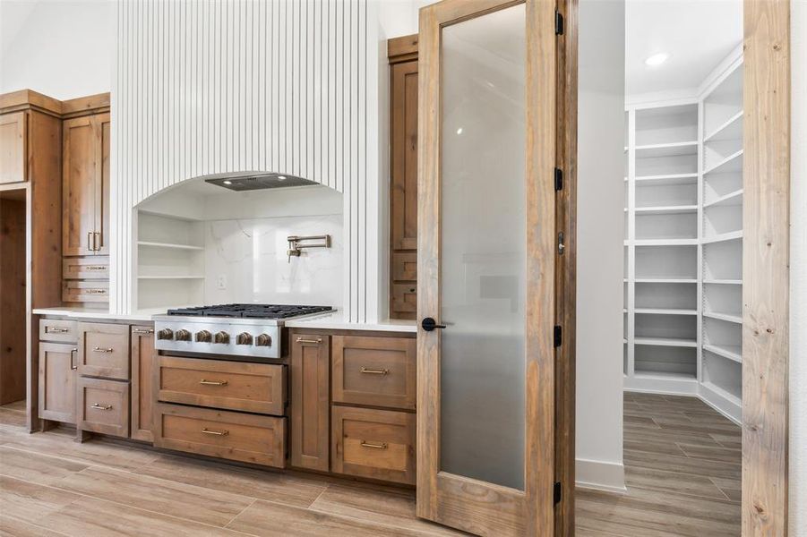 Kitchen with light hardwood / wood-style floors and stainless steel gas stovetop