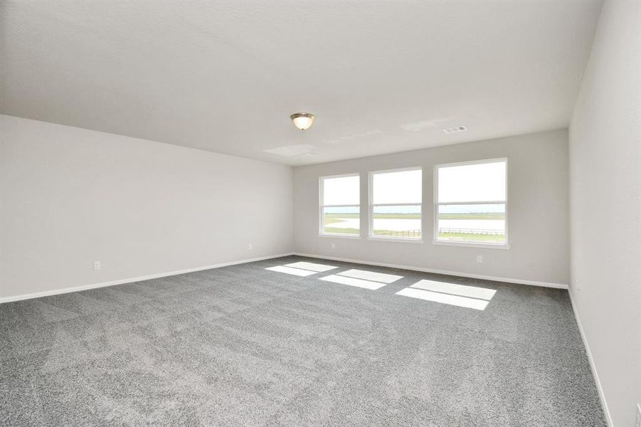 Upstairs game room featuring plush carpet and large windows.