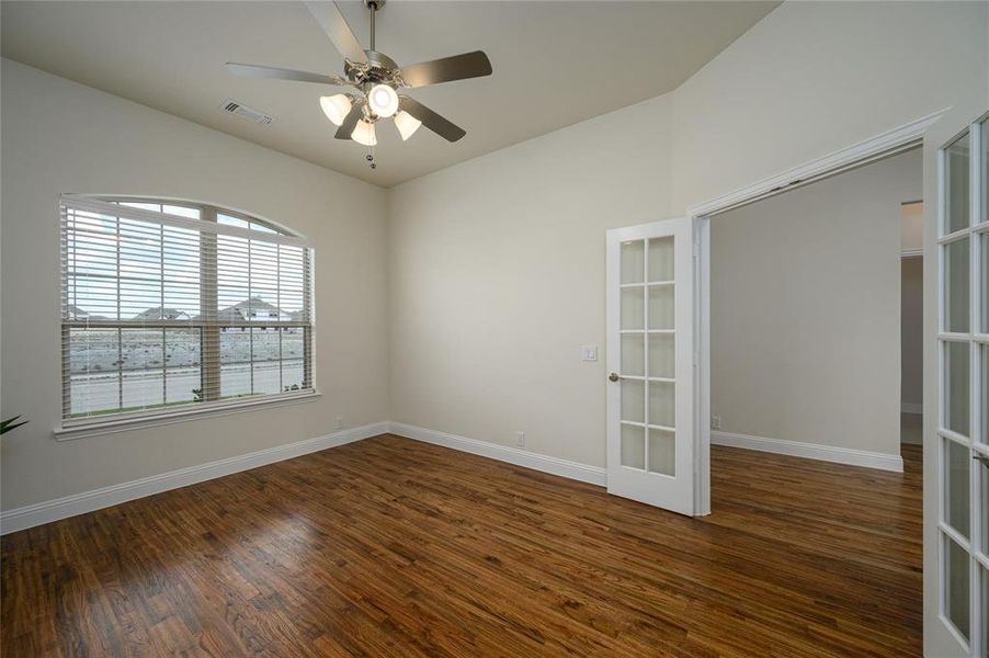 Unfurnished room featuring ceiling fan, french doors, and dark wood-type flooring