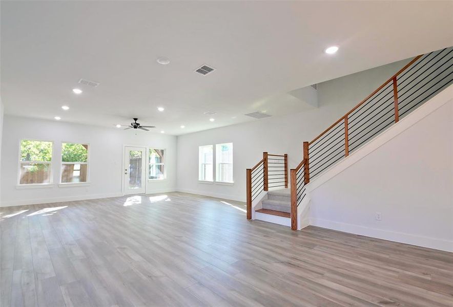 Unfurnished living room featuring ceiling fan, light hardwood / wood-style flooring, and a wealth of natural light