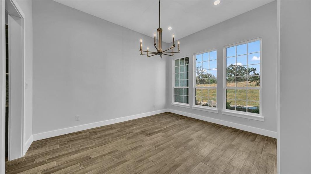 Unfurnished dining area featuring hardwood / wood-style flooring and a notable chandelier