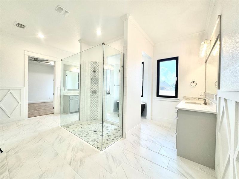 Bathroom with crown molding, tile patterned floors, walk in shower, and vanity