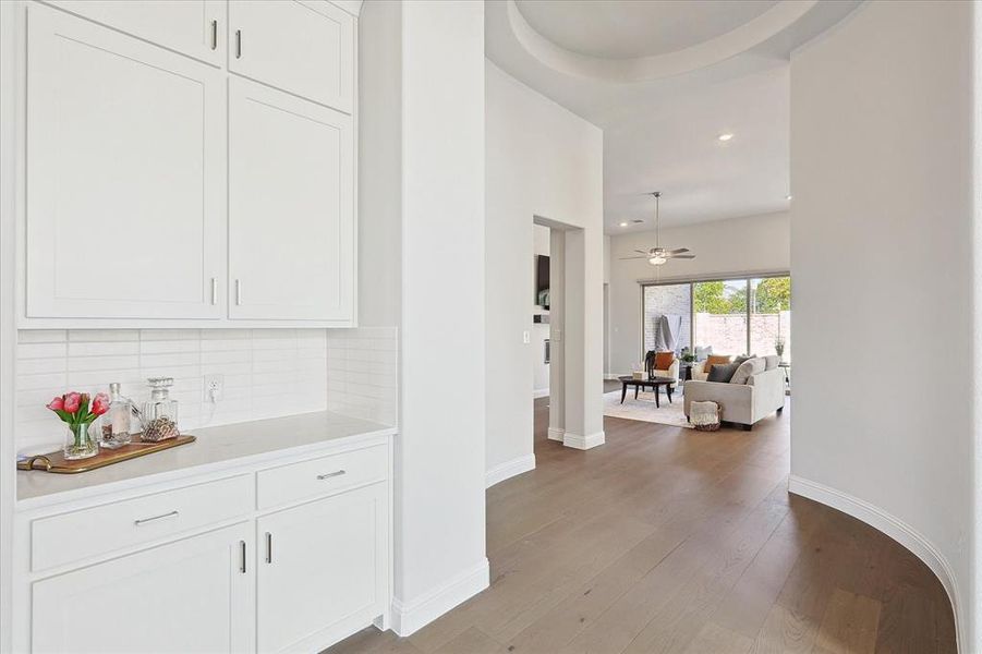 Corridor with light hardwood / wood-style floors and a tray ceiling