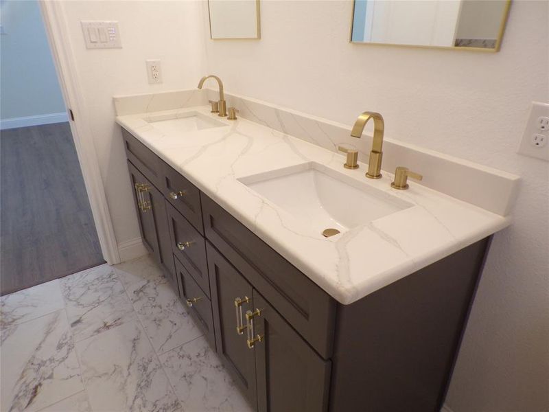 Bathroom featuring dual bowl vanity and tile patterned floors