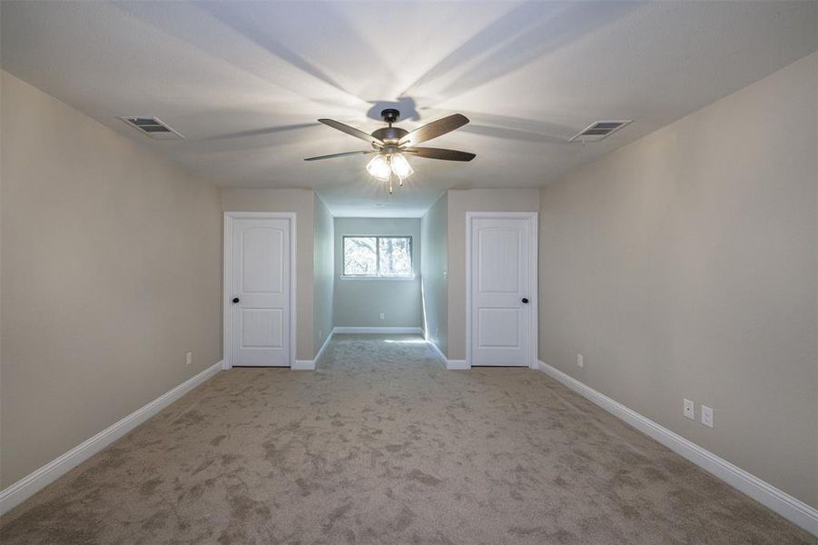 Carpeted spare room featuring ceiling fan