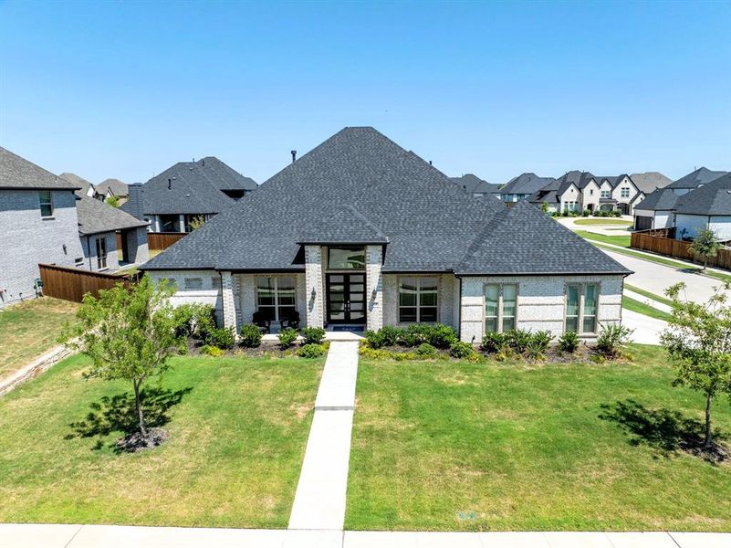 Front elevation with trees and landscaped beds