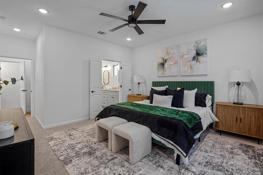 Bedroom with ensuite bath, light carpet, and ceiling fan