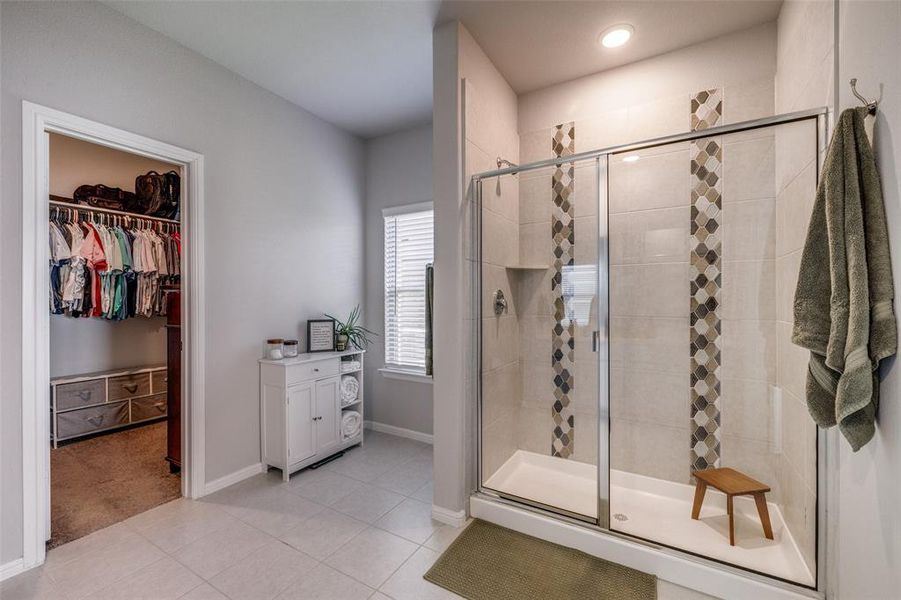 Bathroom with walk in shower and tile patterned floors