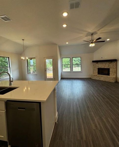 Kitchen featuring dishwasher, lofted ceiling, plenty of natural light, and sink