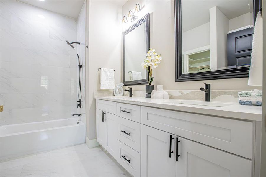 Bathroom with tile floors, dual bowl vanity, and tiled shower / bath