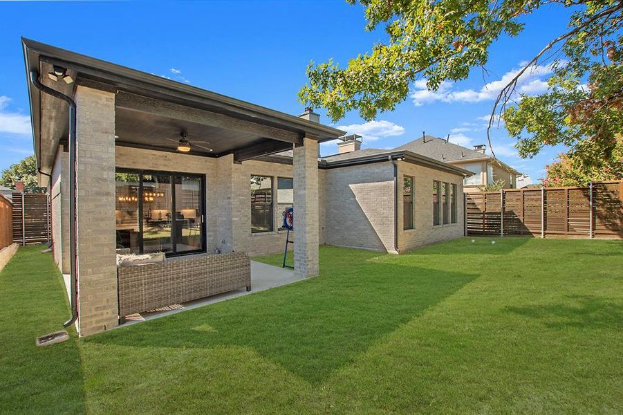 Back of house featuring a yard and ceiling fan