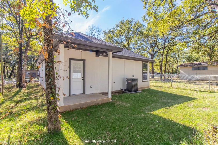 Rear view of house with a patio, a lawn, and cooling unit