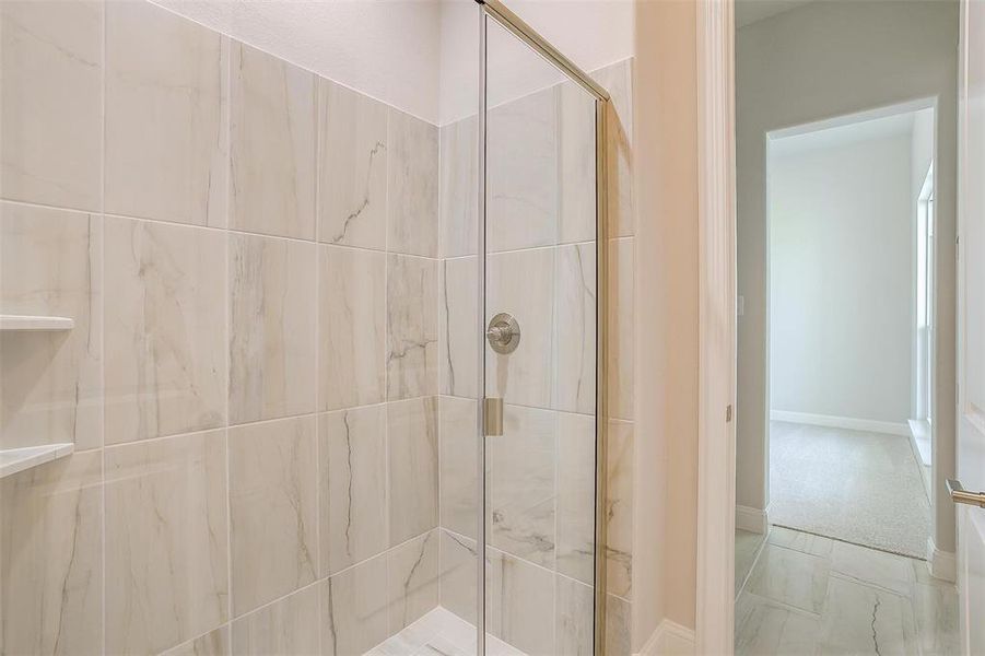 Bathroom featuring a shower with shower door and tile patterned flooring