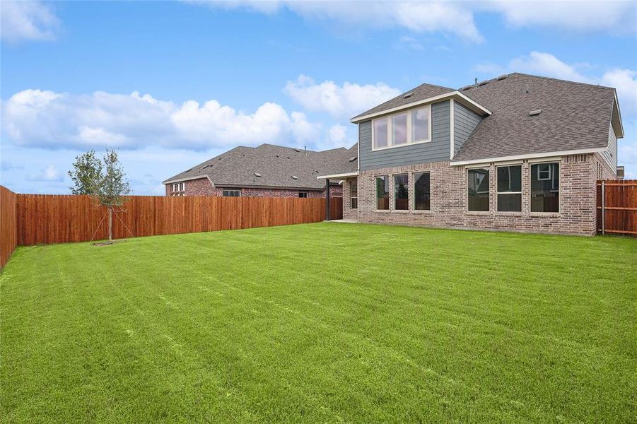 Back of house featuring a yard