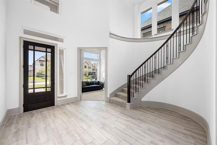 The open floor plan has a dramatic entry with a spiral staircase leading to the second floor. The flex room in the corner is perfect for a home office.