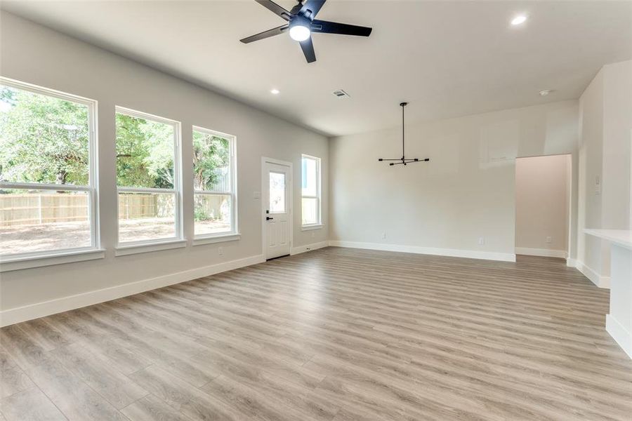 Unfurnished living room with ceiling fan and light hardwood / wood-style floors