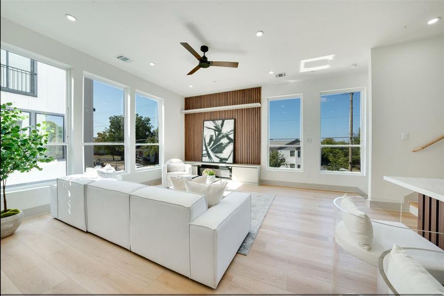 Living room with light hardwood / wood-style floors and ceiling fan