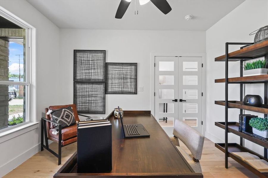 Office with light hardwood / wood-style flooring and ceiling fan