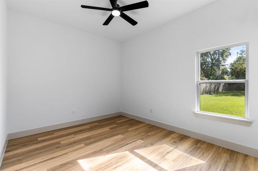 Empty room featuring light hardwood / wood-style floors, plenty of natural light, and ceiling fan