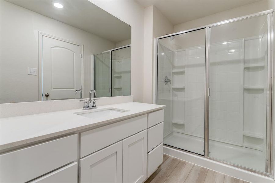 Bathroom with vanity, hardwood / wood-style flooring, and walk in shower