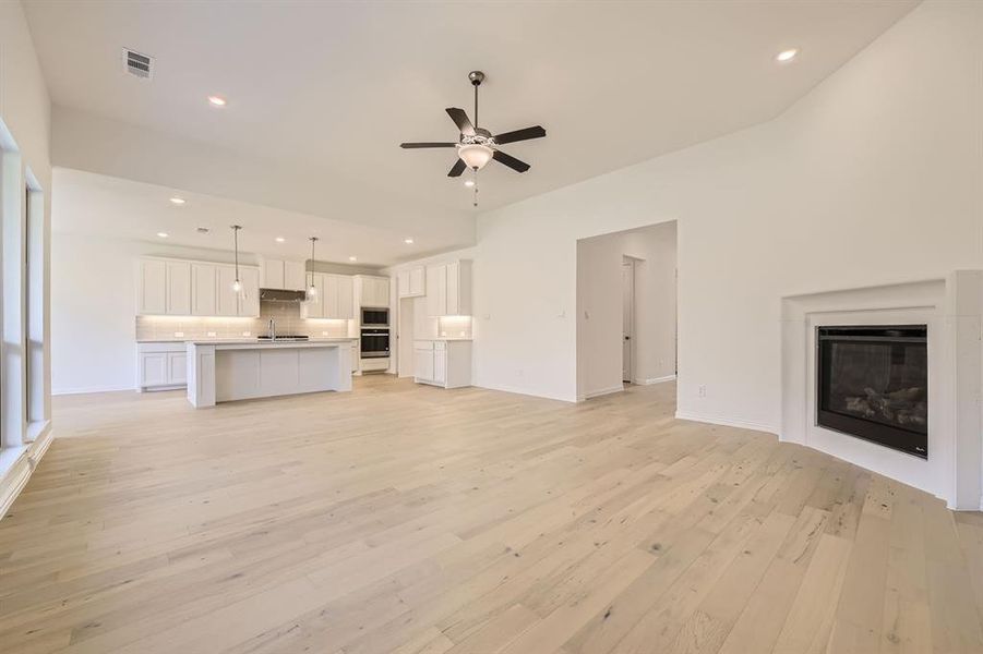 Unfurnished living room with sink, light hardwood / wood-style flooring, and ceiling fan