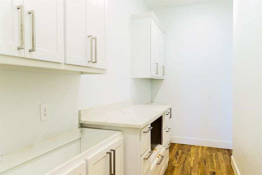 Clothes washing area with dark wood-type flooring