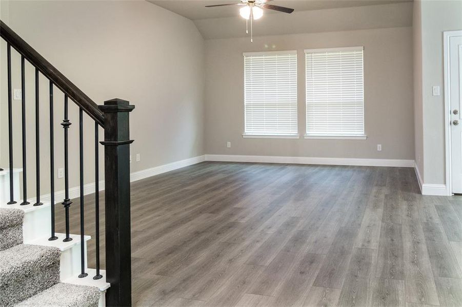 Foyer with lofted ceiling, wood-type flooring, and ceiling fan