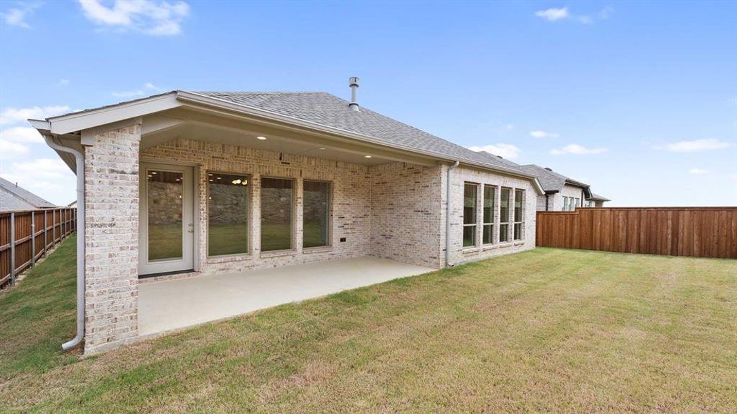 Back of house with a lawn and a patio area